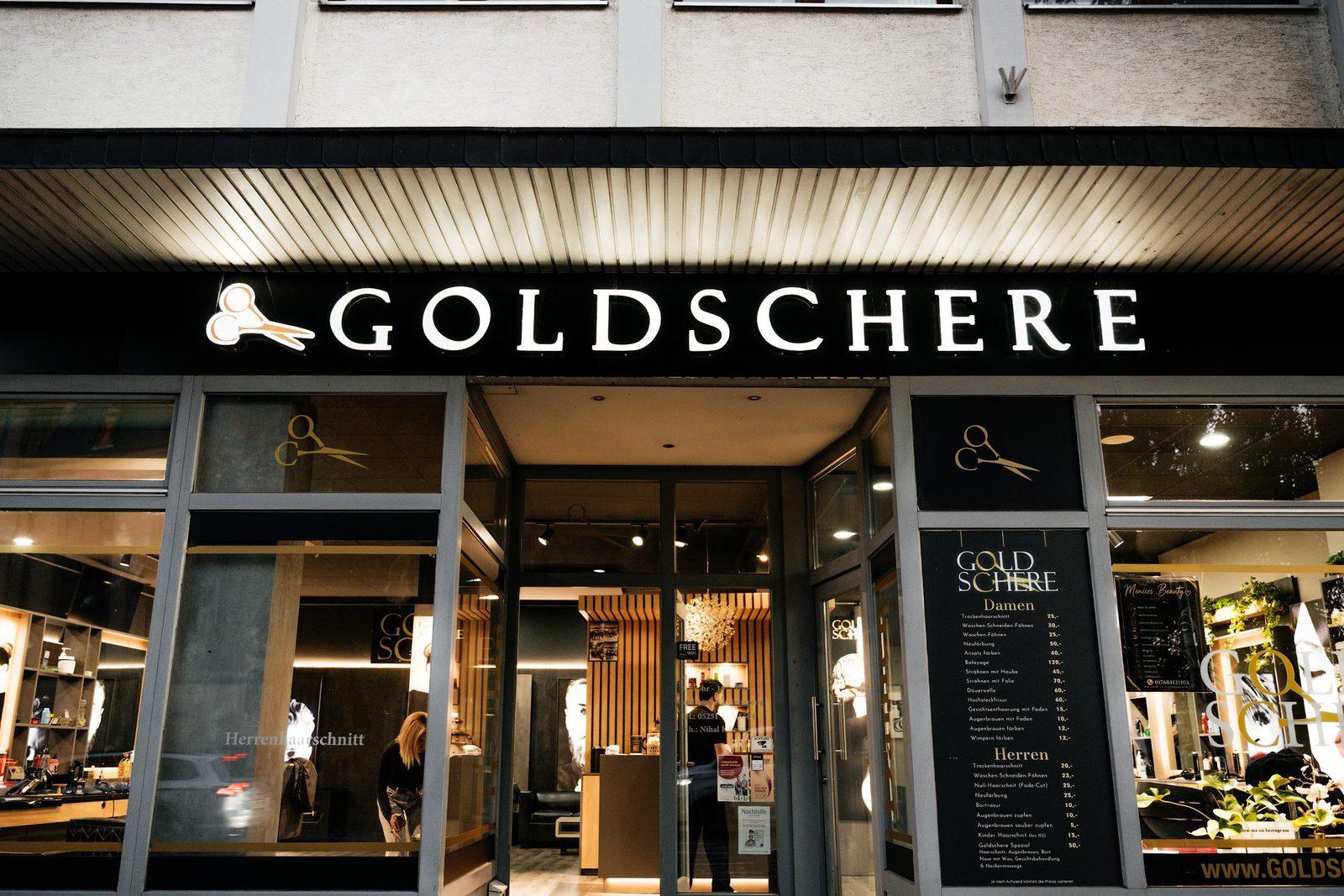 Ladenfront von Goldschere in Paderborn mit beleuchtetem Schriftzug